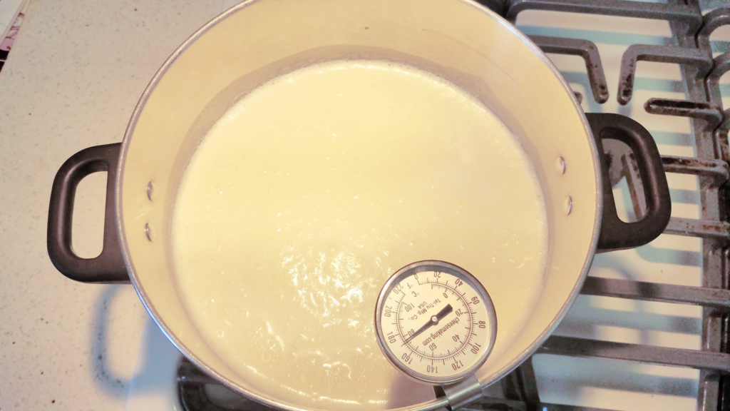 Pot of milk on stove with thermometer