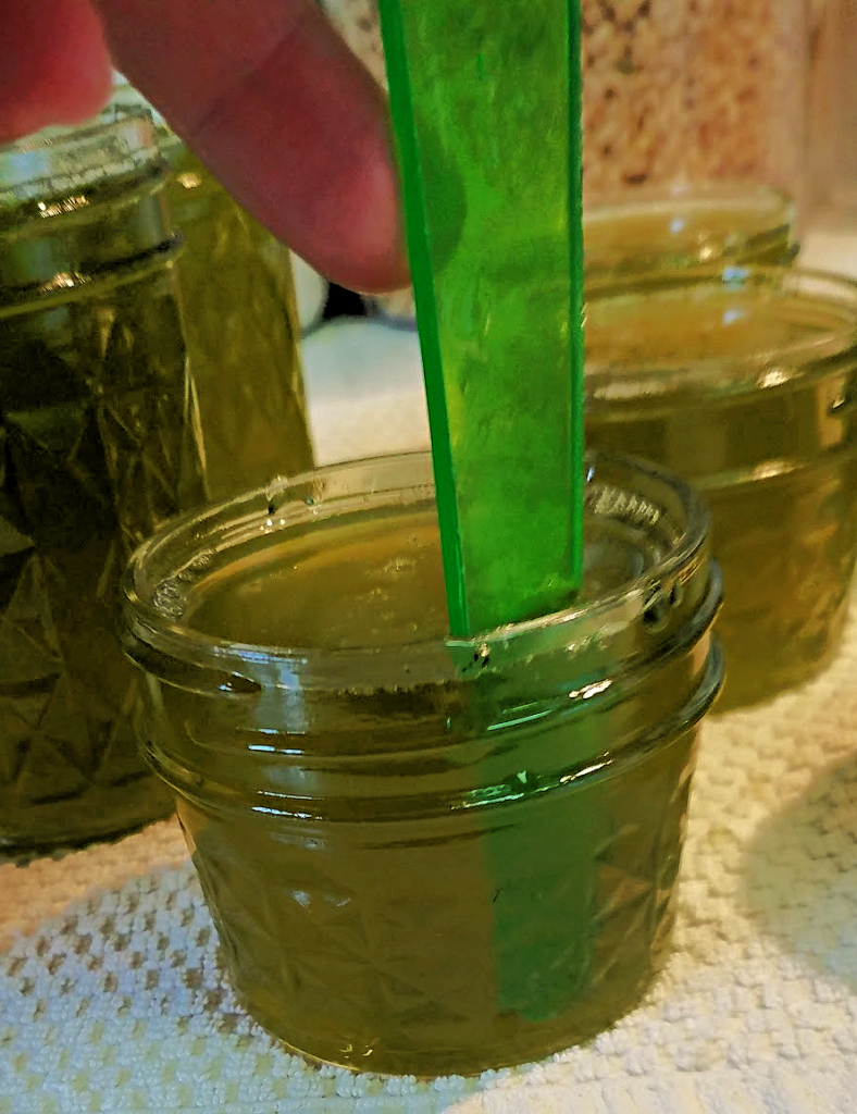 bubble tool in green pepper jelly in jar on towel