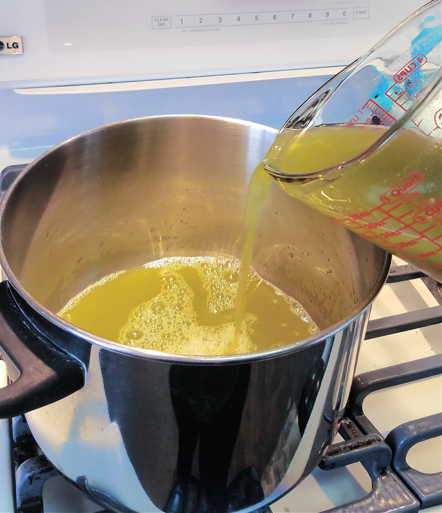Pouring green pepper juice into pot on stove